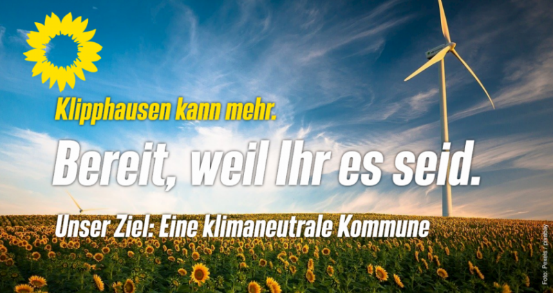 Ein Windrad in einem Sonnenblumenfeld. Text: Klipphausen kann mehr. Bereit, weil Ihr es seid. Unser Ziel: eine klimaneutrale Kommune