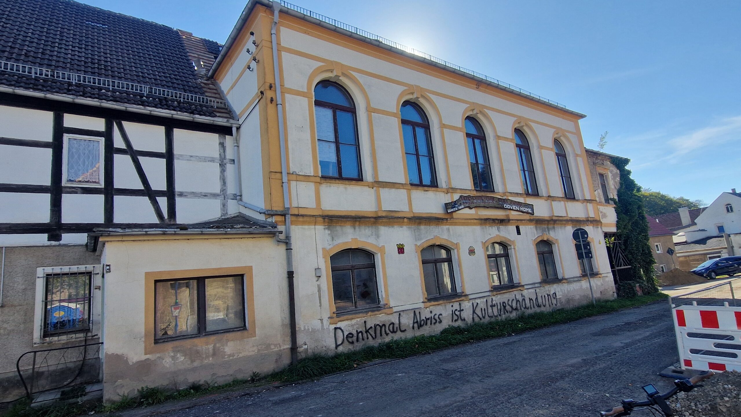 Ansicht Saalanbau Gasthof Taubenheim, Ende September 2026. Deutlich erkennbar ist der gesprayte Schriftzug "Denkmal Abriss ist Kulturschändung".